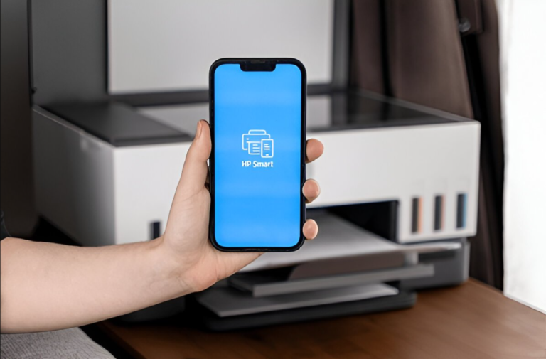 Close-up of a hand holding a smartphone displaying the HP Smart app interface, with a 123 hp com setup in the background.